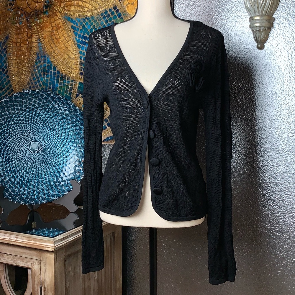 Black crochet cardigan sweater with rose accents.
